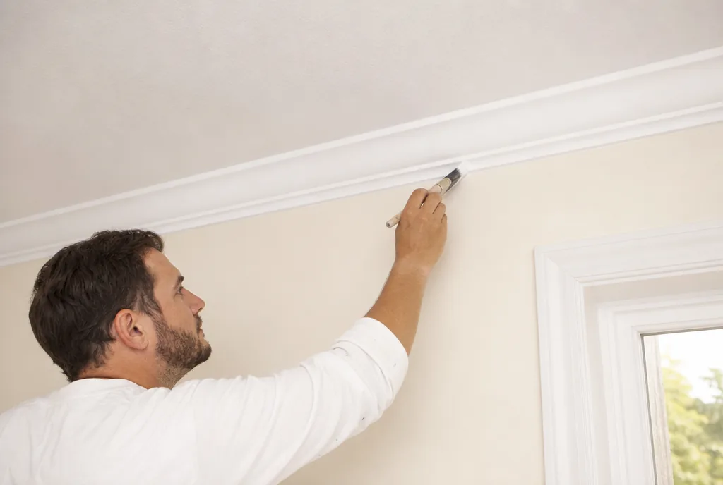 Painter cutting in a crisp edge along ceiling trim