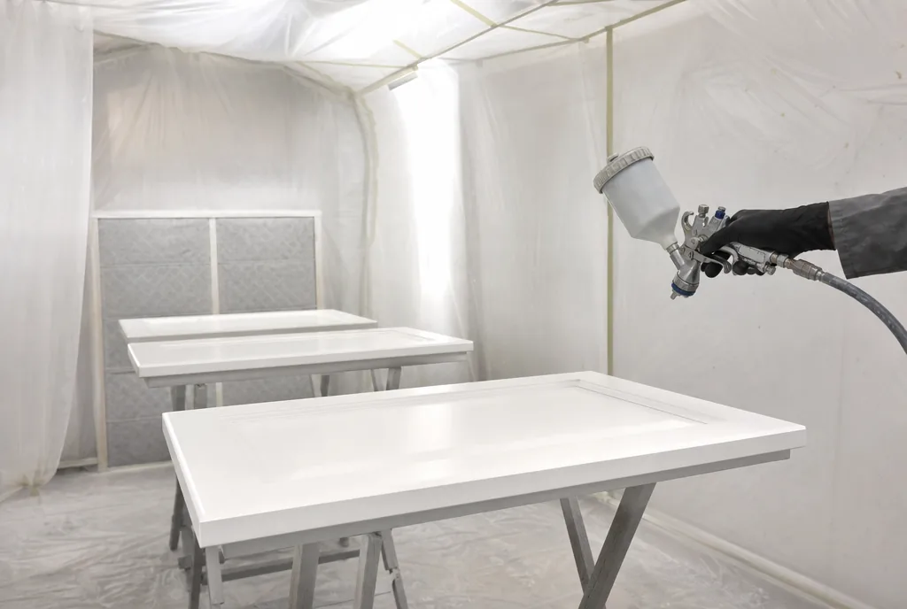 Cabinet doors sprayed satin white in a spray booth